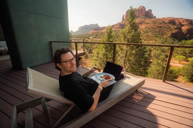tim sykes lounging in arizona with laptop and food on lap
