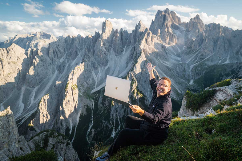 Tim Sykes Italian Alps with a laptop top penny stocks list mindset master