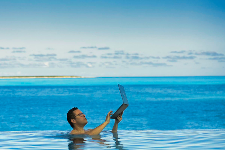 Monday motivation - Tim Sykes swims with laptop exemplifying mindset mastery to achieve success
