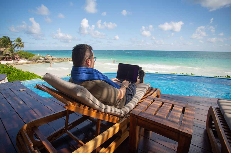 Tim Sykes checks his penny stock positions from Tulum