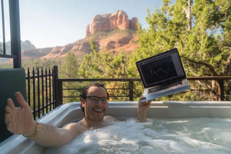 tim sykes in hot tub with laptop and arizona landscape in background