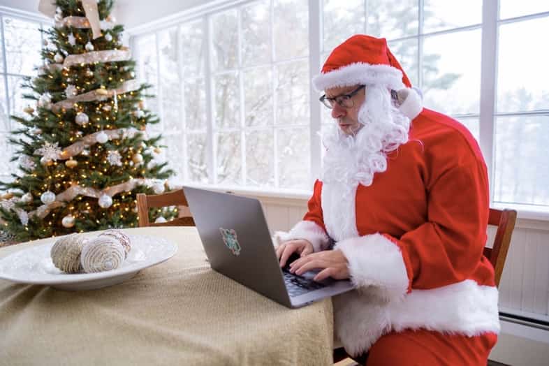 tim sykes dressed as santa sitting at laptop
