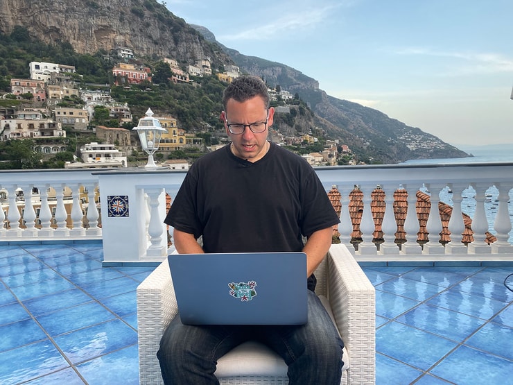 Tim Sykes checking his top penny stocks list in Italy