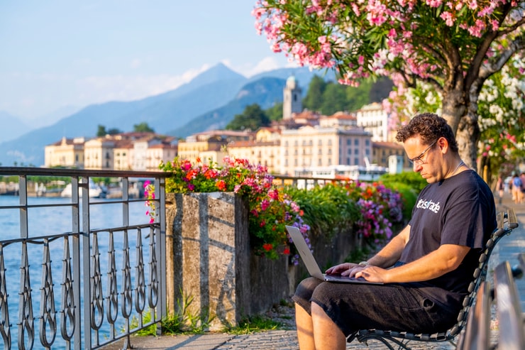 tim sykes on laptop computer by Lake Como